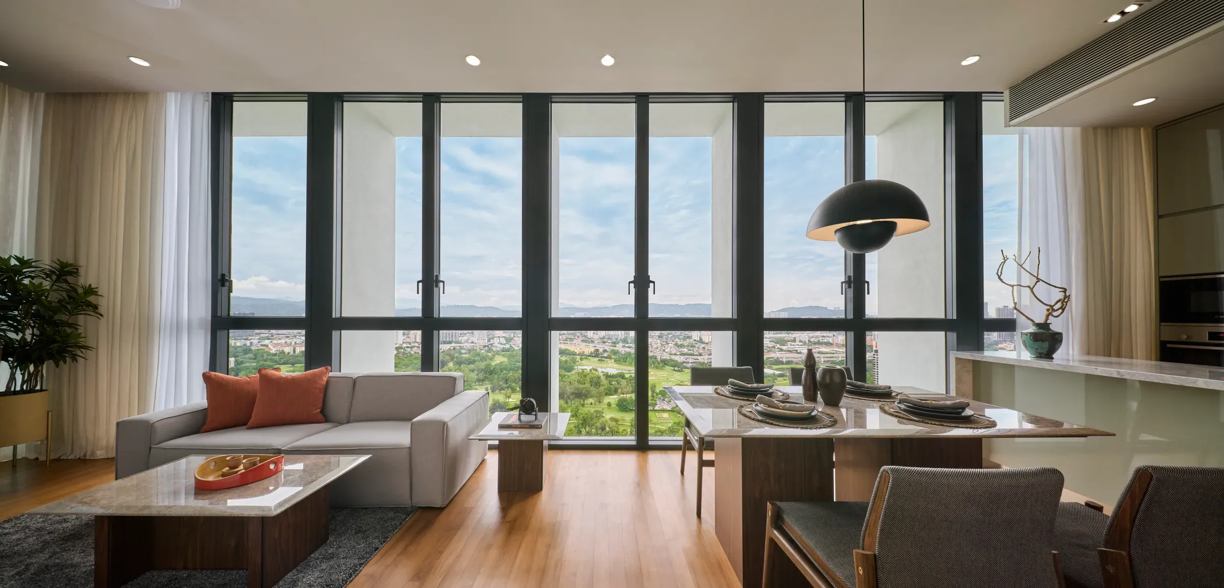 Living and dining opening onto floor-to-ceiling glazing