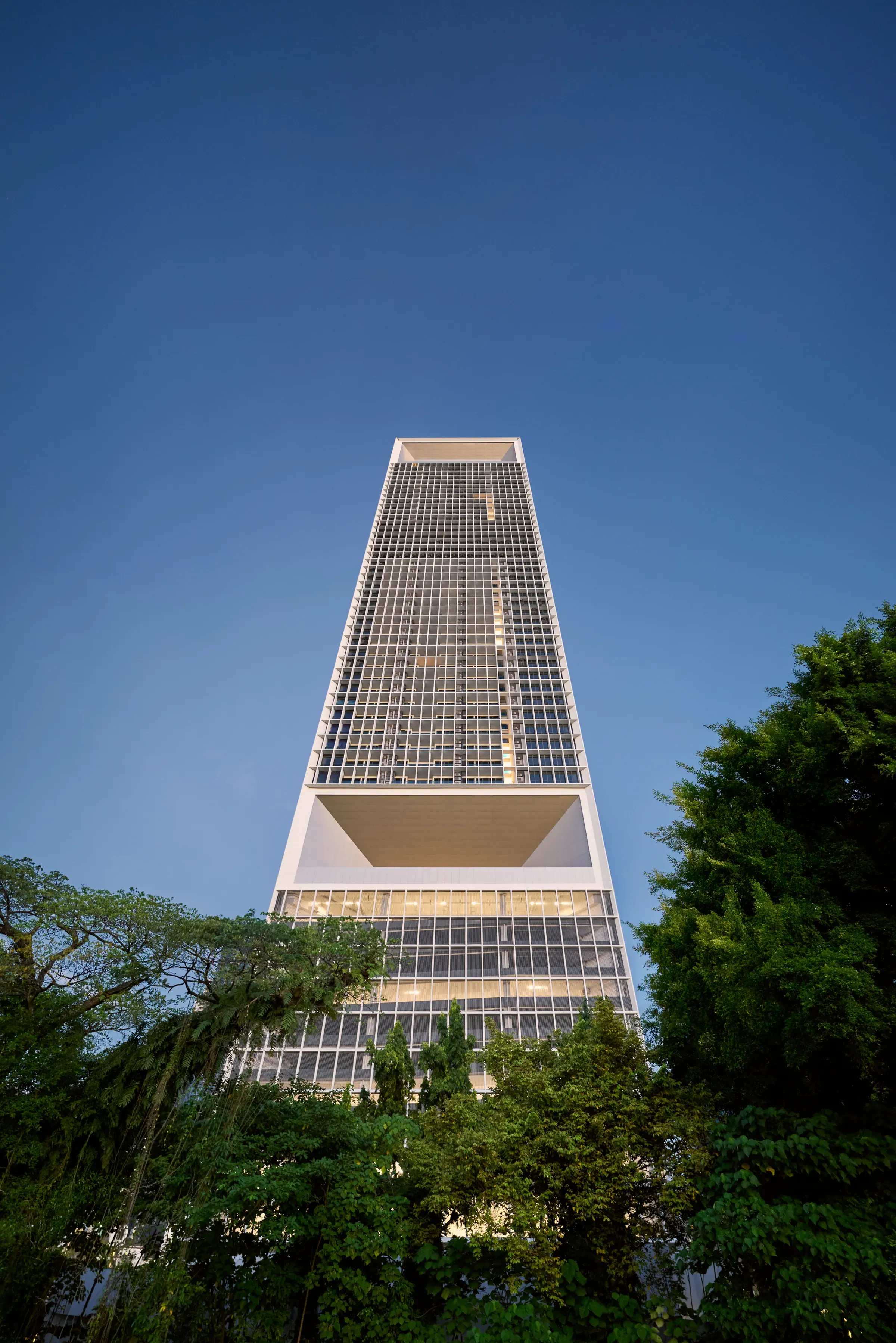 The Conlay Signature Suites tower rising above the trees at dusk
