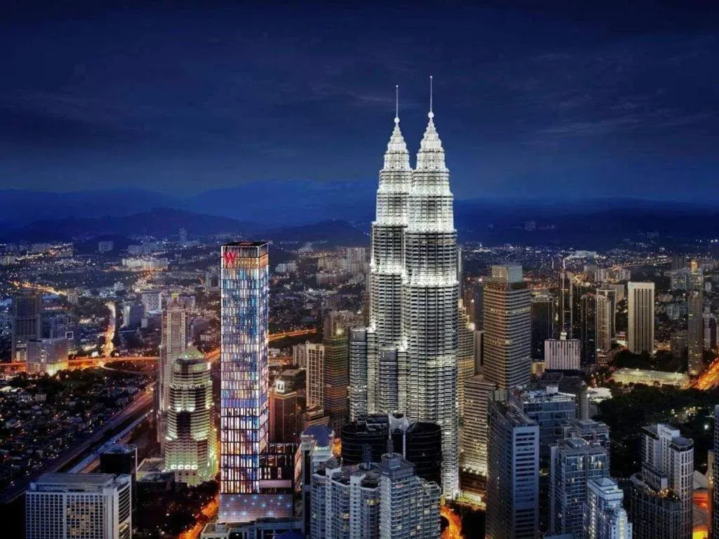 The Petronas Twin Towers lit up over the Kuala Lumpur skyline at night